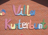 Villa Kunterbunt in bunten Buchstaben auf einer Ziegelmauer 